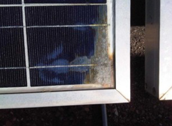 Un módulo fotovoltaico típico con entrada de humedad que muestra signos de rejillas metálicas corroídas, delaminación y decoloración de los encapsulantes.